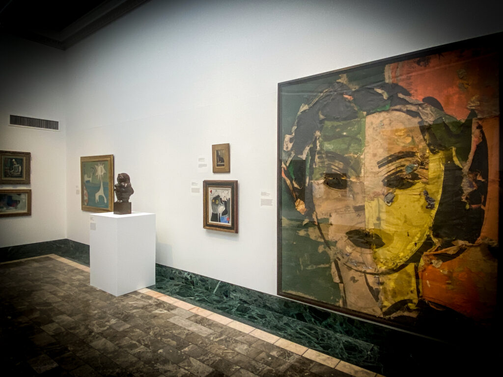 A photo of a room with white walls and framed art on the walls