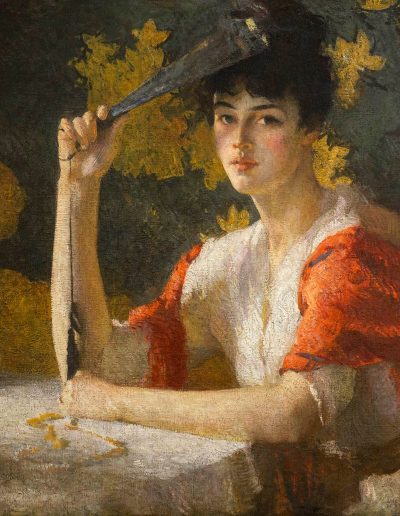 A young woman with pinned up dark hair is sitting at a table; she is wearing a white dress wrapped in a red shawl. She holds a folded black and gold fan while gazing toward the viewer. The wall in the background is black with gold leaf shapes.