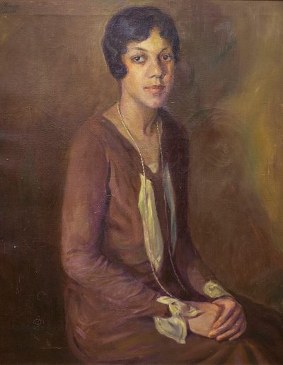 Portrait of an African American woman seated and looking towards the viewer.