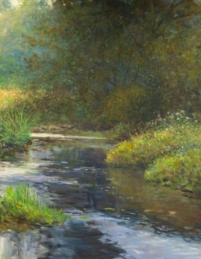 A small creek runs through field of flowers and tall grass.