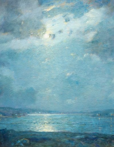 Clouds in the sky slightly obscures the moon over a large calm body of water.