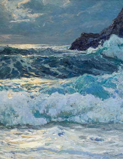 A rocky shore with cliffs in the background. Waves crashing against the shore.