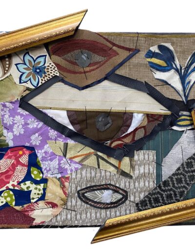 A fabric collage featuring a stylized human face made from various textile scraps, including floral patterns and a bird motif. Two broken pieces of a gold ornate frame are positioned diagonally across the composition, partially overlapping the fabric layers. The artwork uses earthy tones contrasted with pops of purple, blue, and red.